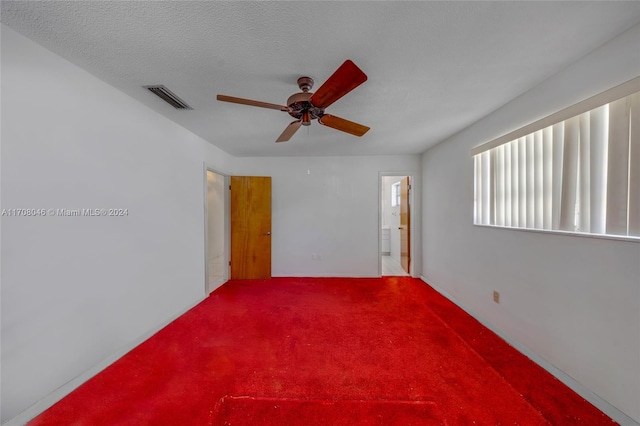 carpeted empty room featuring a textured ceiling and ceiling fan