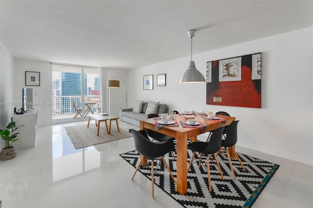 dining space with light tile patterned floors, a textured ceiling, and expansive windows