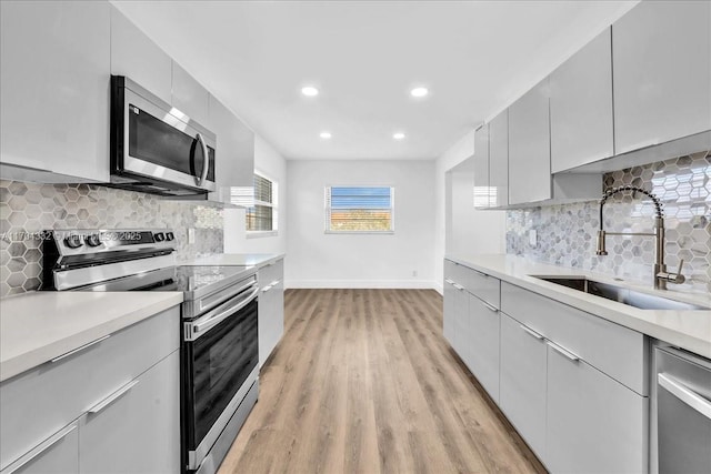1200 SW 130th Ave Unit 412G, Pembroke Pines, FL 33027 - kitchen featuring stainless steel appliances, a sink, light wood finished floors, recessed lighting, and tasteful backsplash