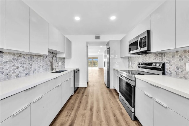 1200 SW 130th Ave Unit 412G, Pembroke Pines, FL 33027 - kitchen with appliances with stainless steel finishes, a sink, light countertops, light wood-style floors, and recessed lighting