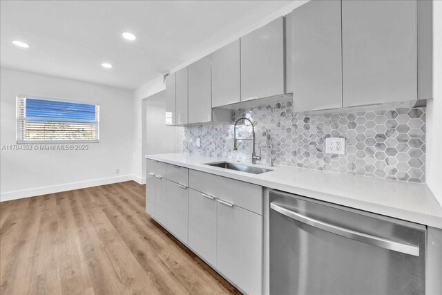 1200 SW 130th Ave Unit 412G, Pembroke Pines, FL 33027 - kitchen with dishwasher, a sink, light countertops, baseboards, and light wood finished floors