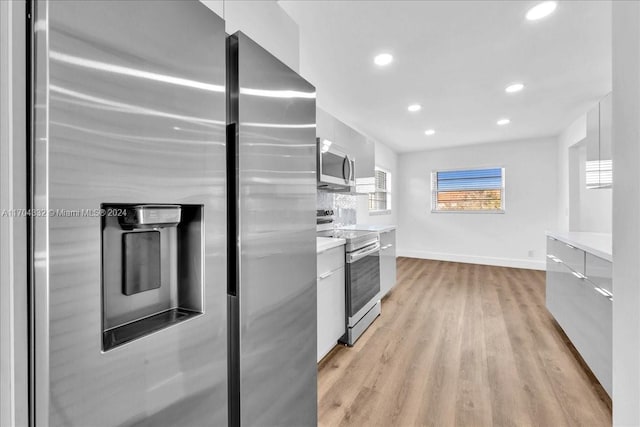 kitchen featuring light hardwood / wood-style flooring, white cabinets, and appliances with stainless steel finishes