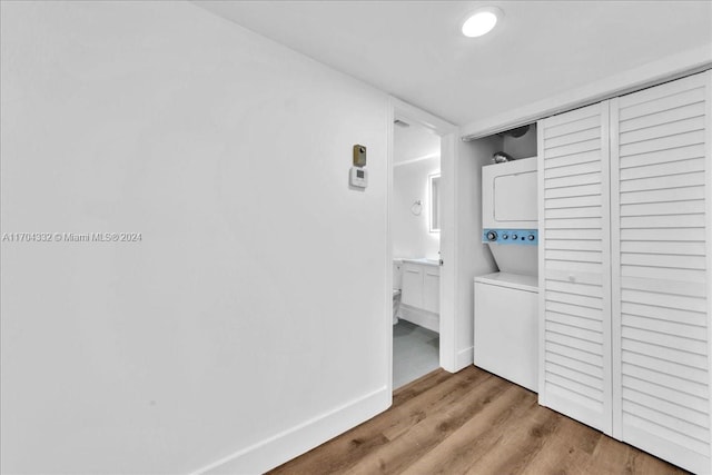 hall featuring light hardwood / wood-style floors and stacked washer and dryer