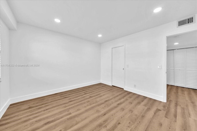 unfurnished bedroom with a closet and light hardwood / wood-style floors