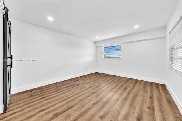 1200 SW 130th Ave Unit 412G, Pembroke Pines, FL 33027 - spare room featuring wood finished floors, recessed lighting, baseboards, and a barn door