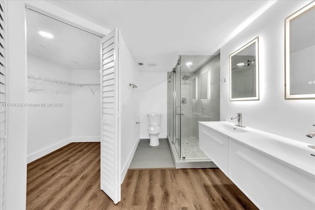 1200 SW 130th Ave Unit 412G, Pembroke Pines, FL 33027 - bathroom featuring a shower stall, toilet, wood finished floors, a walk in closet, and baseboards