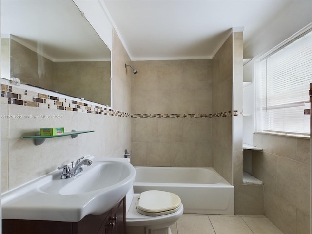 full bathroom with tile patterned floors, toilet, vanity, tile walls, and tiled shower / bath