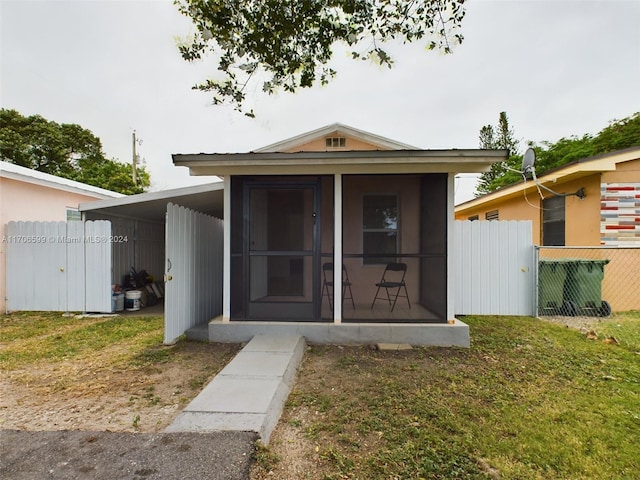 rear view of property with a lawn and a carport