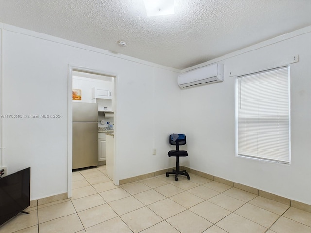 tiled spare room with a textured ceiling and a wall mounted AC