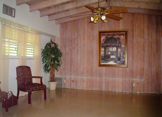 sitting room with wood walls, vaulted ceiling with beams, and ceiling fan