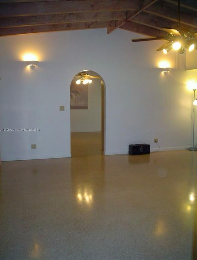 empty room with vaulted ceiling with beams