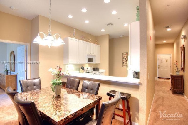 dining area with light carpet and an inviting chandelier