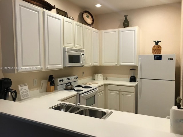 kitchen featuring white cabinetry, sink, and white appliances