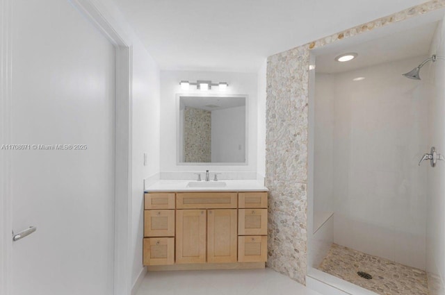 bathroom featuring tile patterned floors, vanity, and a shower