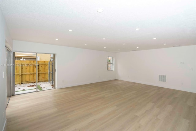 unfurnished room featuring a textured ceiling and light wood-type flooring