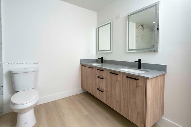 bathroom with vanity, wood-type flooring, and toilet