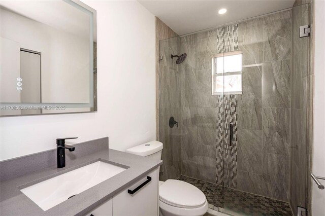 bathroom with hardwood / wood-style flooring, toilet, a skylight, and a tile shower