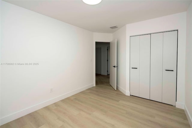 unfurnished bedroom featuring light hardwood / wood-style floors and a closet