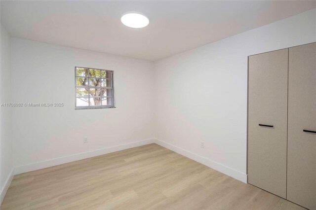 unfurnished bedroom with light hardwood / wood-style flooring and a closet