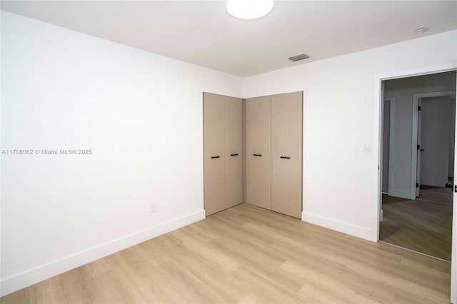 unfurnished bedroom with a closet and light hardwood / wood-style flooring