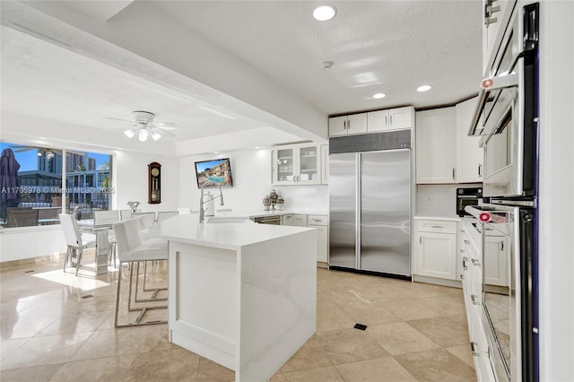 1960 NE 118th Rd, North Miami, FL 33181 - kitchen featuring stainless steel appliances, a sink, white cabinets, light countertops, and recessed lighting