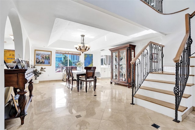 1960 NE 118th Rd, North Miami, FL 33181 - dining area featuring a raised ceiling, a chandelier, arched walkways, stairs, and baseboards