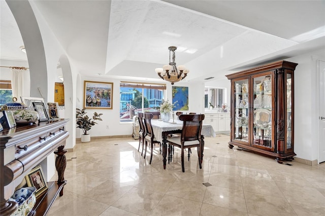 dining area with a chandelier and a tray ceiling