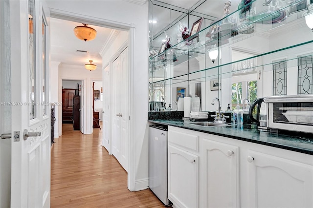 bar with white cabinetry, sink, dishwasher, light wood-type flooring, and ornamental molding