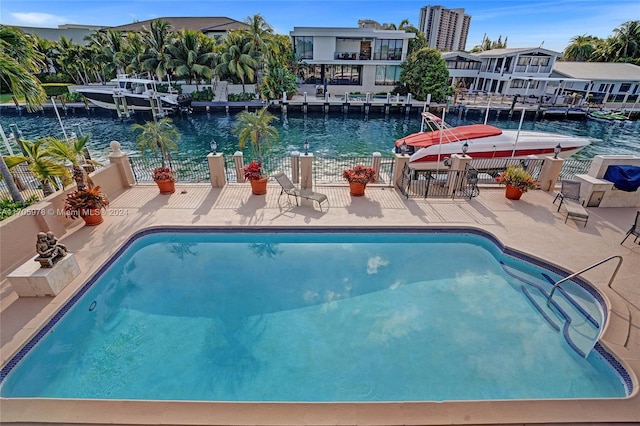 view of pool featuring a water view and a patio