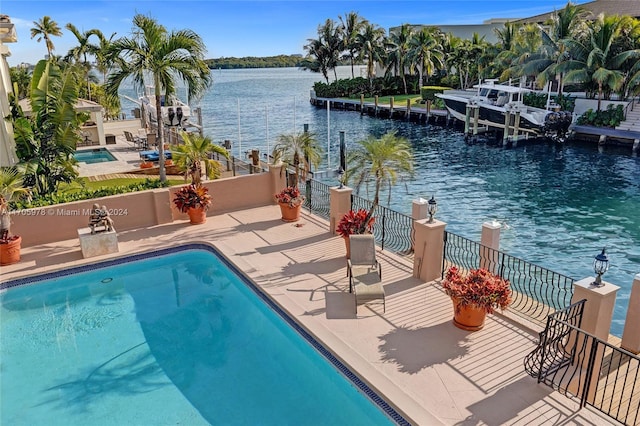 view of pool featuring a patio area and a water view