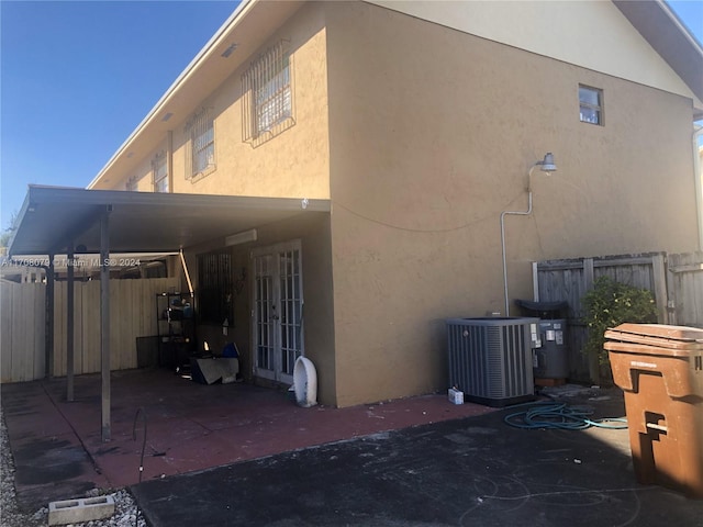 rear view of house with cooling unit and a carport