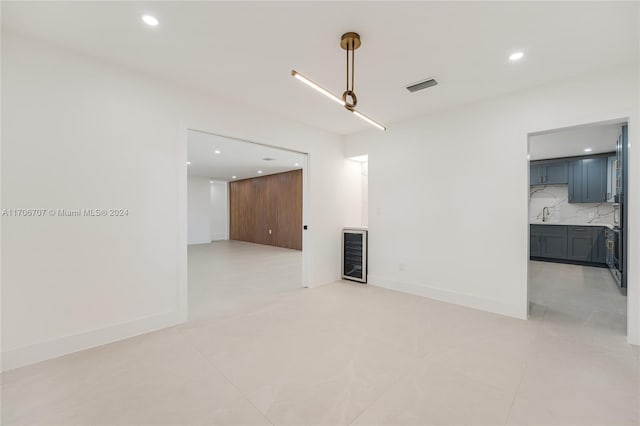 tiled spare room with sink and beverage cooler