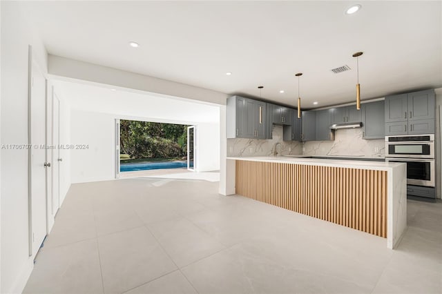 kitchen with tasteful backsplash, gray cabinetry, light tile patterned flooring, and double oven