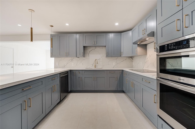 kitchen featuring gray cabinetry, sink, tasteful backsplash, decorative light fixtures, and appliances with stainless steel finishes