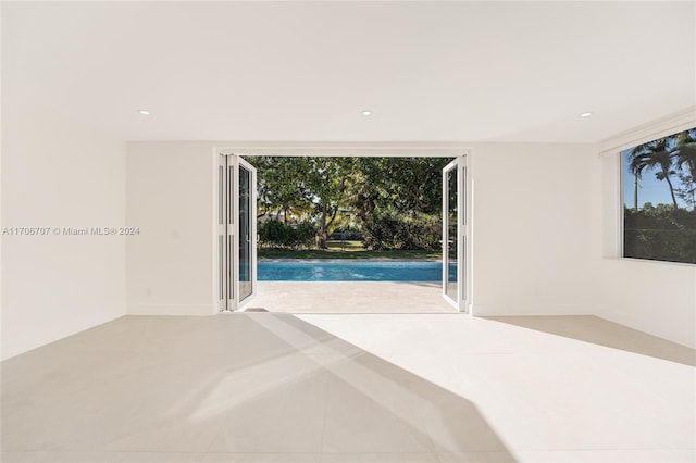 unfurnished bedroom featuring access to exterior and light tile patterned flooring