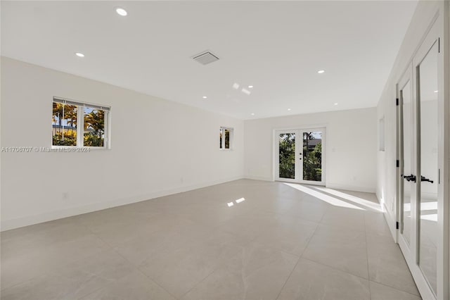 empty room with french doors and light tile patterned flooring