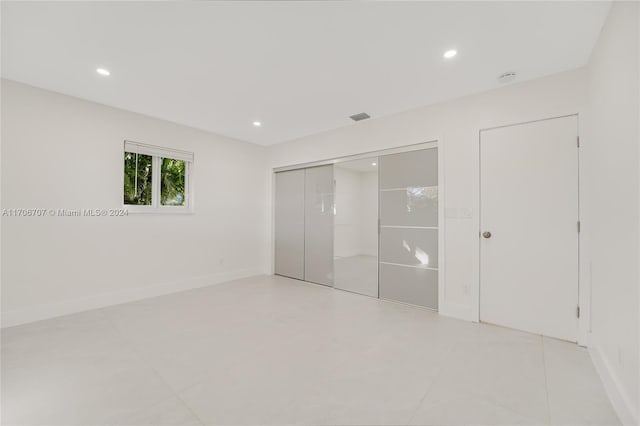 unfurnished bedroom with light tile patterned flooring and a closet