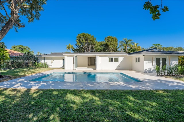 view of pool with a patio area and a lawn