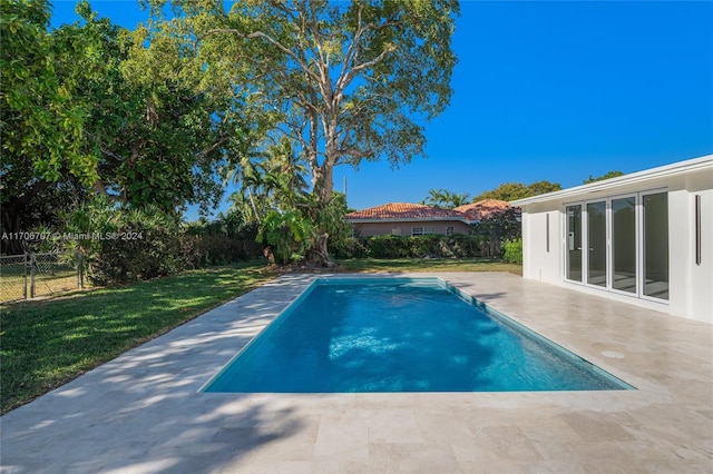 view of swimming pool featuring a lawn and a patio