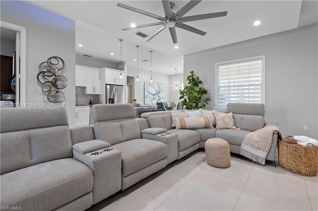 tiled living room featuring ceiling fan with notable chandelier