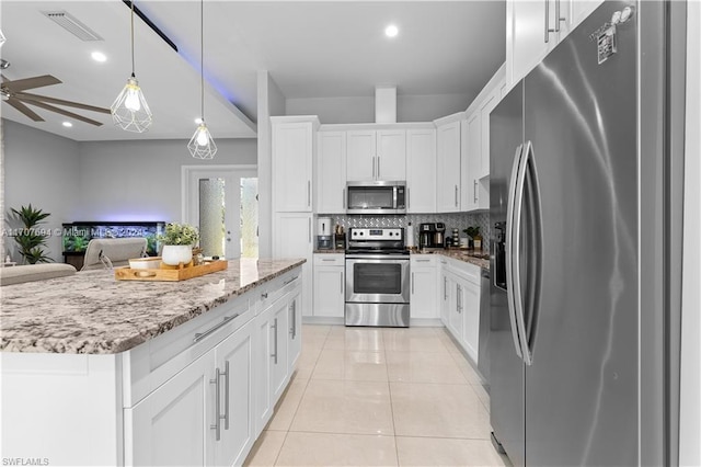 kitchen featuring white cabinetry, ceiling fan, hanging light fixtures, backsplash, and appliances with stainless steel finishes