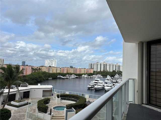 balcony with a community hot tub and a water view