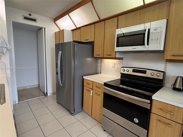 kitchen with light tile patterned floors and stainless steel appliances