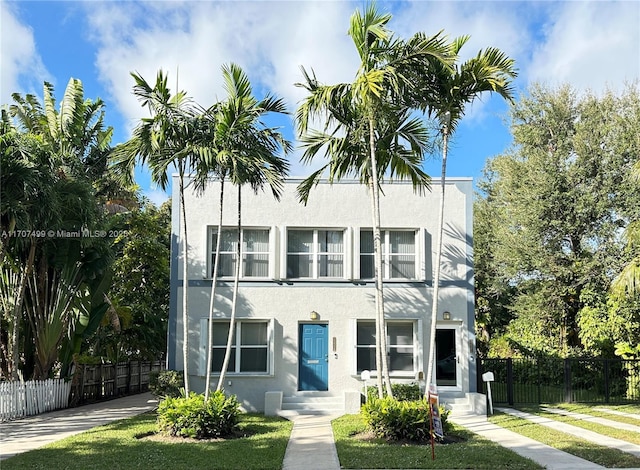 view of front of house featuring fence and stucco siding