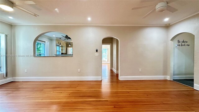 empty room featuring light wood-type flooring and crown molding