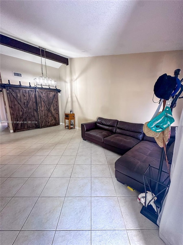 living room with beamed ceiling, light tile patterned flooring, and a textured ceiling