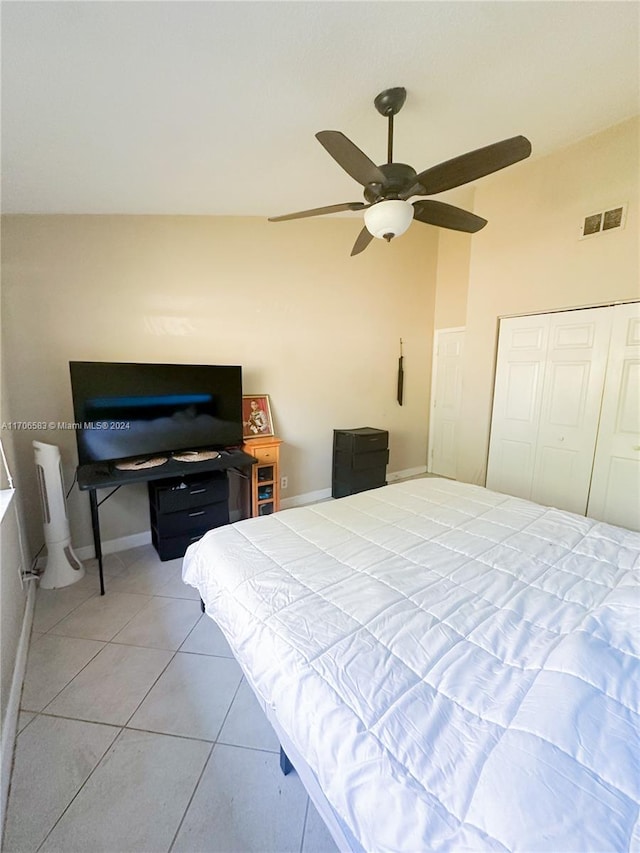 tiled bedroom featuring a closet, ceiling fan, and lofted ceiling