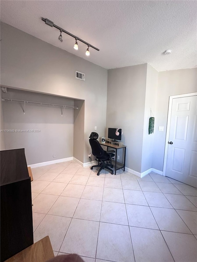 tiled home office featuring a textured ceiling