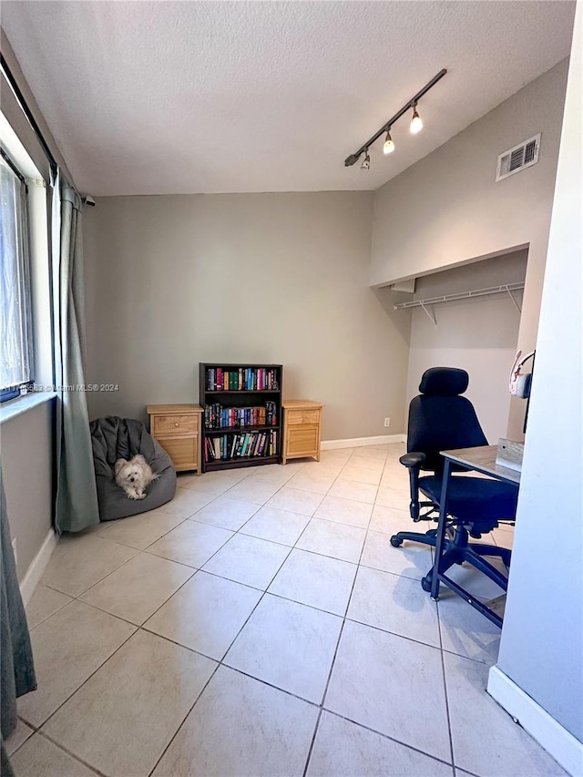 home office with light tile patterned floors and a textured ceiling