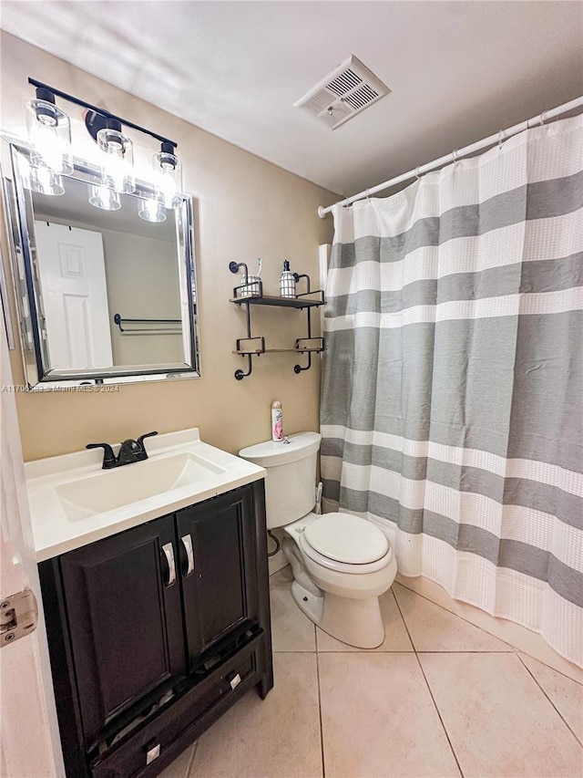 bathroom featuring toilet, vanity, tile patterned floors, and walk in shower